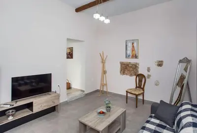 a living room with a couch and a tv at Kalliston City House with a Yard in Chania Town