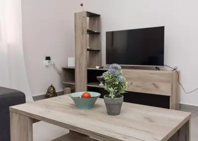 a living room with a wooden coffee table with a tv at Kalliston City House with a Yard in Chania Town