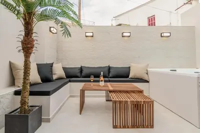 a patio with a couch and a table and a palm tree at MOS Luxury Suits 