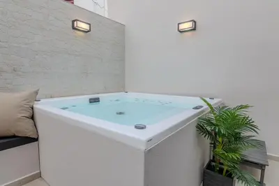 a bathtub in the corner of a room with a plant at MOS Luxury Suits 