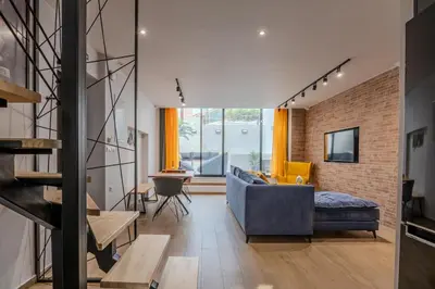 a living room with a blue couch and a brick wall at MOS Luxury Suits 