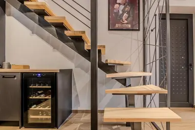 a staircase in a loft with a table and benches at MOS Luxury Suits 