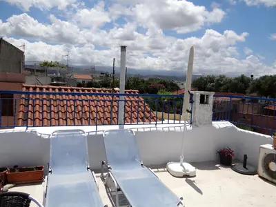 a balcony with two blue benches on a roof at Villa Archondisa in Chania Town
