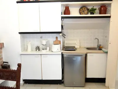 a small kitchen with white cabinets and a sink at Villa Archondisa in Chania Town