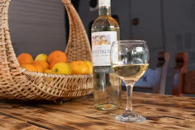 a glass of white wine next to a basket of fruit at Lemon Garden Camper in Chania Town