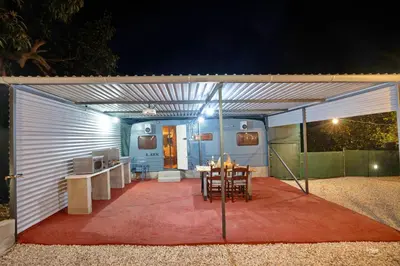 a white garage with a table and chairs in it at Lemon Garden Camper in Chania Town