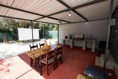 a covered patio with a table and chairs and a screen at Lemon Garden Camper in Chania Town