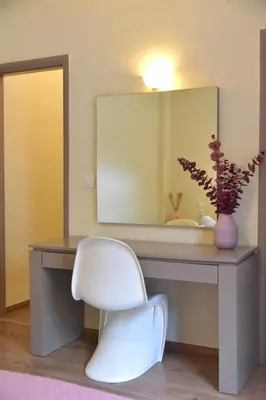a white chair sitting in front of a desk with a mirror at Madrugada in Chania Town