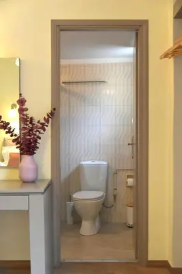 a bathroom with a toilet and a vase with a plant at Madrugada in Chania Town