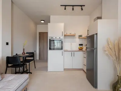 a kitchen with a white refrigerator and a table at Aura Urban Living in the heart of Chania city in Chania Town