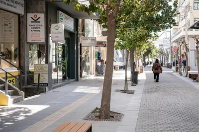 a woman walking down a sidewalk in a city at Aura Urban Living in the heart of Chania city in Chania Town