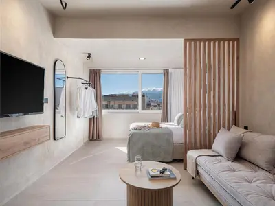 a living room with a couch and a bed and a television at Aura Urban Living in the heart of Chania city in Chania Town