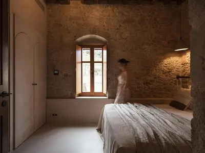 a woman standing on a bed in a room with a window at Corte Interna, free heated pool in Kalivianí