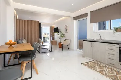 a kitchen and living room with a table and chairs at Anele Luxury Suites - Roof Top Jacuzzi in Chania Town