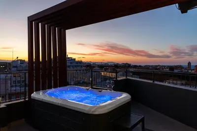 a bath tub on a balcony with a sunset at Anele Luxury Suites - Roof Top Jacuzzi in Chania Town
