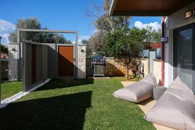 a backyard with a fence and a lawn with a couch at Studio Verde Glaros w. Outdoors, near the Beach in Kato Daratso