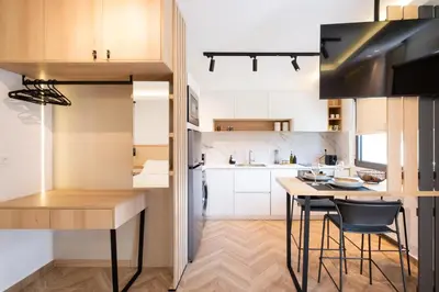 a kitchen with white cabinets and a table and chairs at Studio Verde Glaros w. Outdoors, near the Beach in Kato Daratso