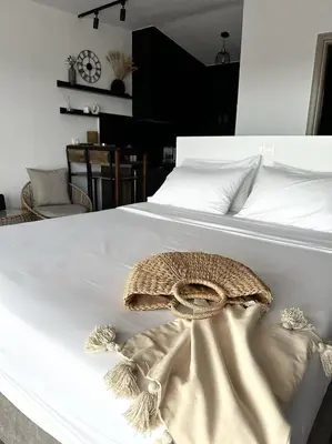 a white bed with a hat on top of it at Serenity Living in Palaiochóra