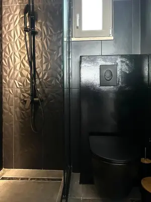 a black bathroom with a shower and a toilet at Serenity Living in Palaiochóra