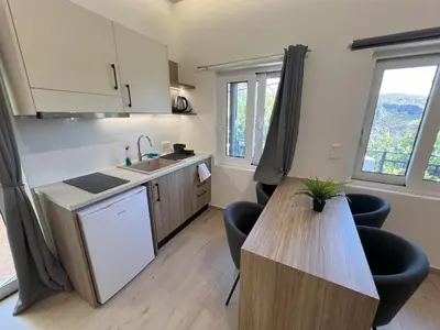 a kitchen with a table and chairs in a room at AZOGIRE Resort in Azoyirés