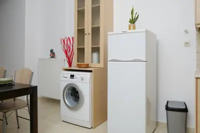 a kitchen with a refrigerator and a washing machine at AVRA COZY APARTMENT Agioi Apostoloi Chania in Daratso