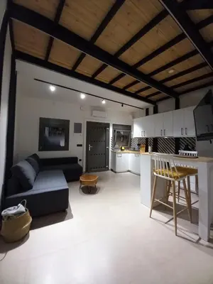 a living room with a couch and a kitchen at Gkerola house - small cozy house close to Chania town center in Chania Town