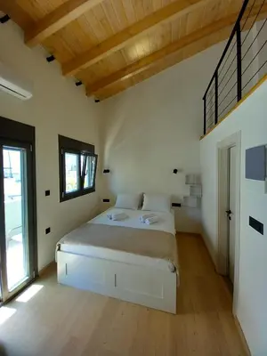 a bedroom with a large bed and a large window at Gkerola house - small cozy house close to Chania town center in Chania Town