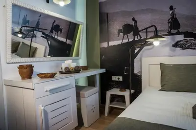 a bedroom with a bed with a desk and a picture on the wall at Elia Daliani in Chania Town