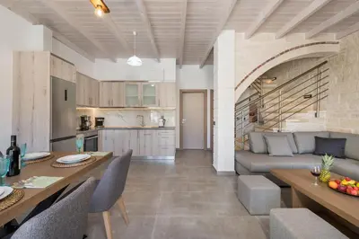 a kitchen and living room with a couch and a table at Sun Flower Villas in Agia Marina Nea Kydonias