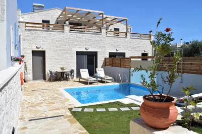 a villa with a swimming pool and a patio at Sun Flower Villas in Agia Marina Nea Kydonias