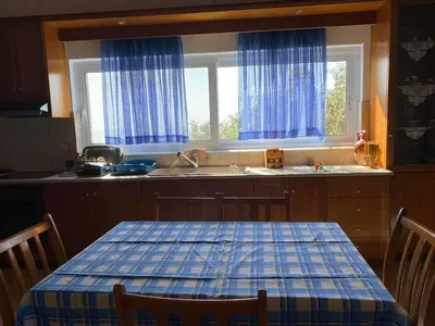 a kitchen with a table and a sink and two windows at Evgoro in Chania Town