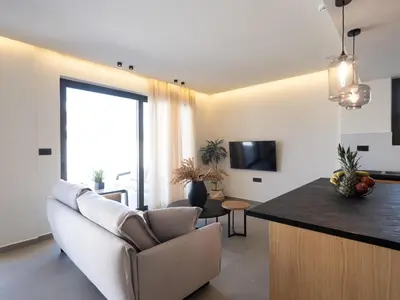 a living room with a couch and a table at Mossa Concept Villas - heated pool- 200 m from the beach in Daratso