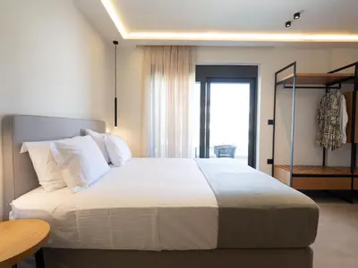 a bedroom with a large white bed and a window at Mossa Concept Villas - heated pool- 200 m from the beach in Daratso