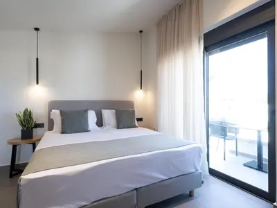 a bedroom with a large bed and a large window at Mossa Concept Villas - heated pool- 200 m from the beach in Daratso