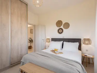a bedroom with a large bed with a tray on it at Sol Luxury Apartment - close to the beach with a private heated mini pool in Chania Town