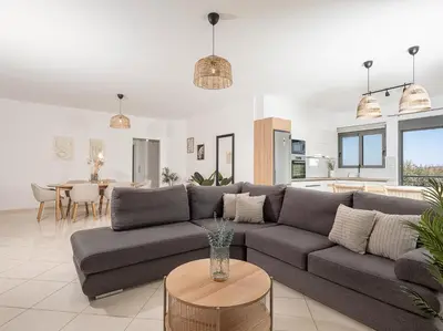 a living room with a couch and a table at Sol Luxury Apartment - close to the beach with a private heated mini pool in Chania Town