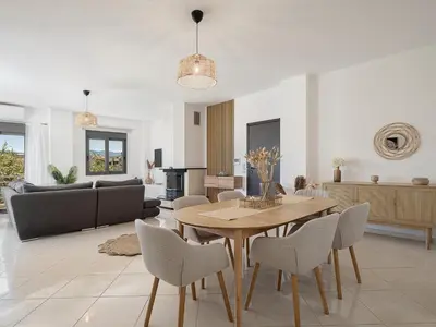 a dining room and living room with a table and chairs at Sol Luxury Apartment - close to the beach with a private heated mini pool in Chania Town