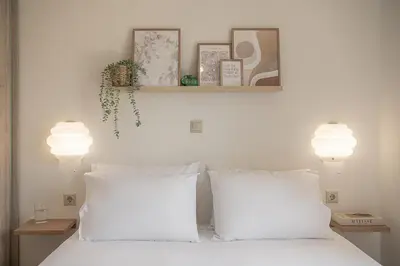 a bedroom with two white pillows and two lights at Sol Luxury Apartment - close to the beach with a private heated mini pool in Chania Town