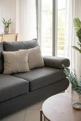 a gray couch in a living room with a table at Sol Luxury Apartment - close to the beach with a private heated mini pool in Chania Town