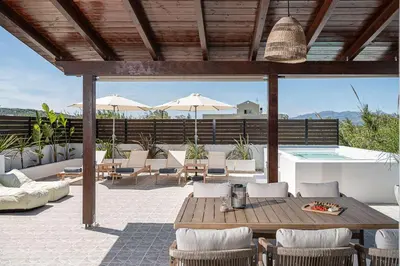 a patio with a table and chairs and a pool at Sol Luxury Apartment - close to the beach with a private heated mini pool in Chania Town