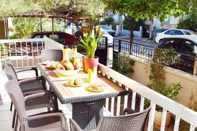 a table with a bowl of fruit on a balcony at NAMA -Central vacation rental with free parking only 900m far from Venetian Port and beach! in Chania Town