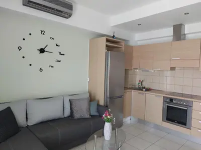 a living room with a couch and a clock on the wall at Eva's Suite in Chania Town