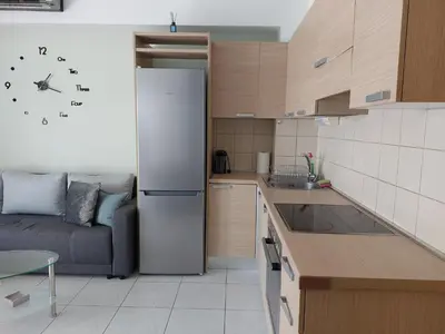 a kitchen with a refrigerator and a couch in a room at Eva's Suite in Chania Town