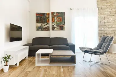 a living room with a couch and a table at Delvia Luxury Residence in Agios Onoufrios