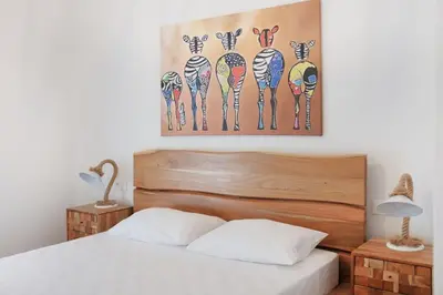 a bedroom with a bed and a painting of zebras at Delvia Luxury Residence in Agios Onoufrios