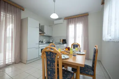 a kitchen with a wooden table and chairs and a table and chairsktop at Zoe's Place - 1 BD Beachfront Apartment in Kissamos