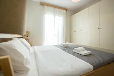 a bedroom with a large white bed with towels on it at Zoe's Place - 1 BD Beachfront Apartment in Kissamos
