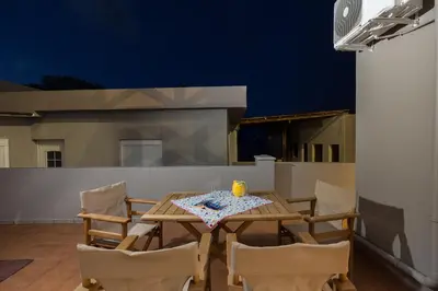 a table and chairs with a candle on a patio at Zoe's Place - 1 BD Beachfront Apartment in Kissamos