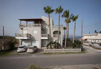 a building with two cars parked in front of it at Zoe's Place - 1 BD Beachfront Apartment in Kissamos