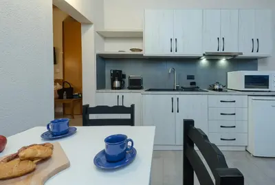 a kitchen with white cabinets and a table with bread on it at Zoe's Place - 1 BD Loft Beachfront Apartment in Kissamos